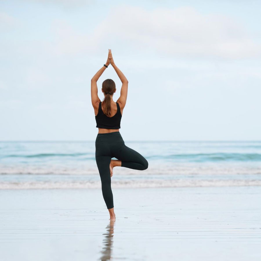 A woman doing yoga on a beach