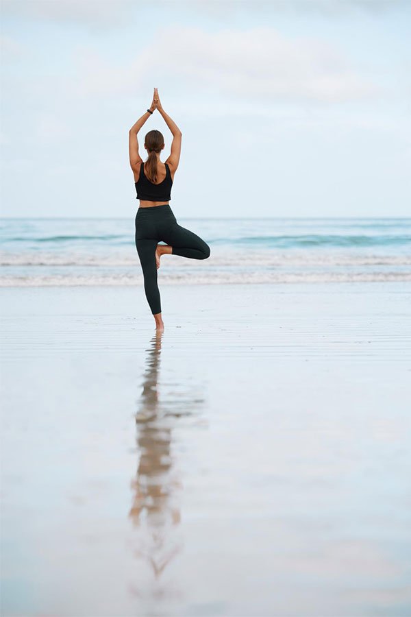 A woman doing yoga on a beach