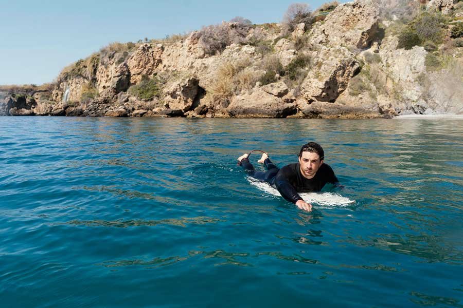 A man paddling on a surfboard