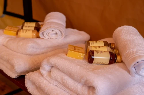 Some clean towels with soap, shampoo and body washes in bottle atop them