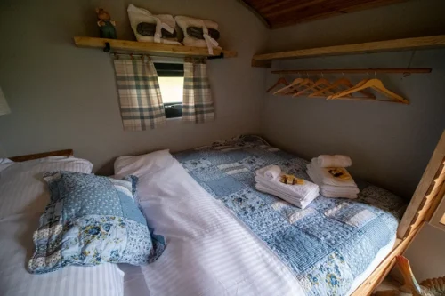 Cwtch Shepherd Hut - Double bed with towels upon it