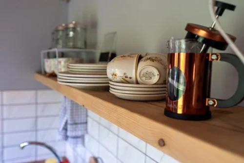 Cwtch Shepherd Hut - Copper-coloured cafetiere with cups above a sink