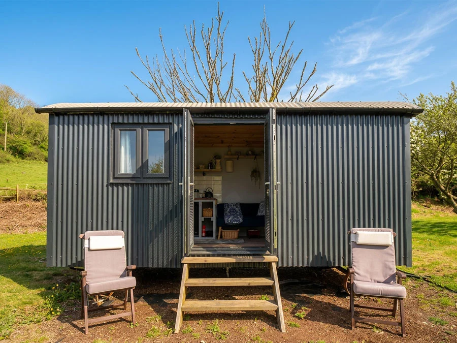 Outside of the Cwtch Shepherd hut with sunshine