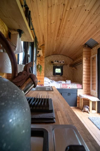 The Nook Shepherd Hut - A view from the kitchen area of a kettle and the double bed