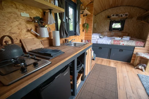 The Nook Shepherd Hut - Interior view of the kitchen area and double bed