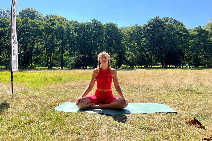 April, a part of our surf & yoga retreat in cornwall, sitting on a yoga mat